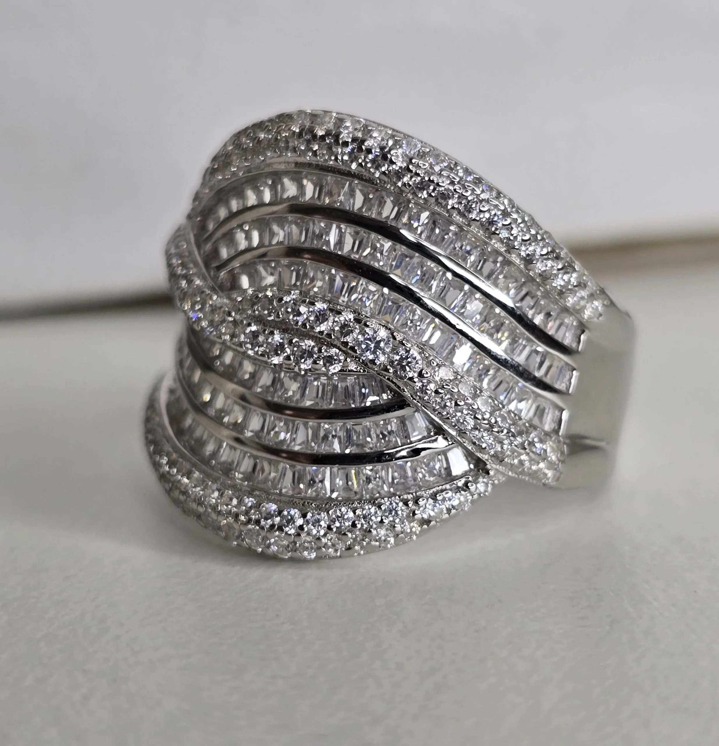 Importante anillo de plata rodinada cruzado, con cubics engarzados. Importado