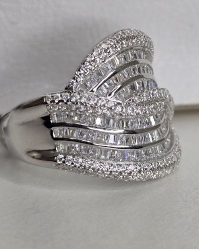 Importante anillo de plata rodinada cruzado, con cubics engarzados. Importado