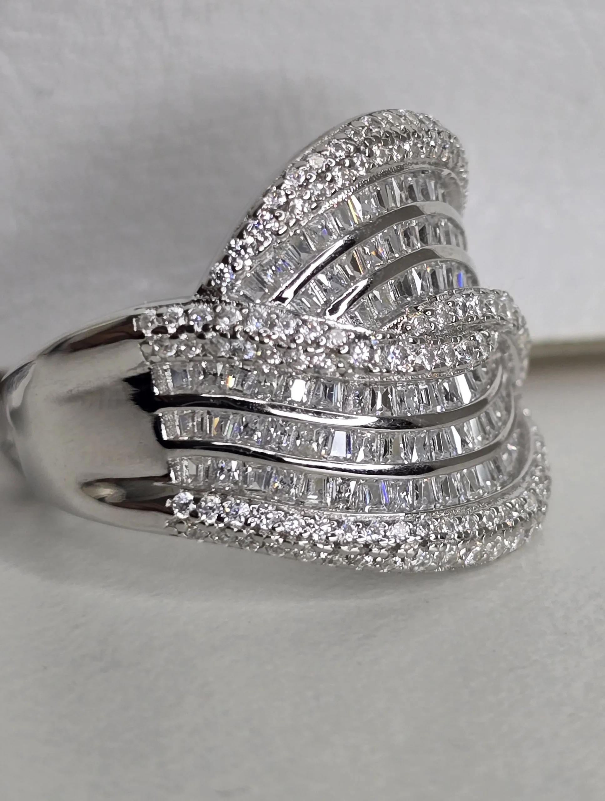 Importante anillo de plata rodinada cruzado, con cubics engarzados. Importado