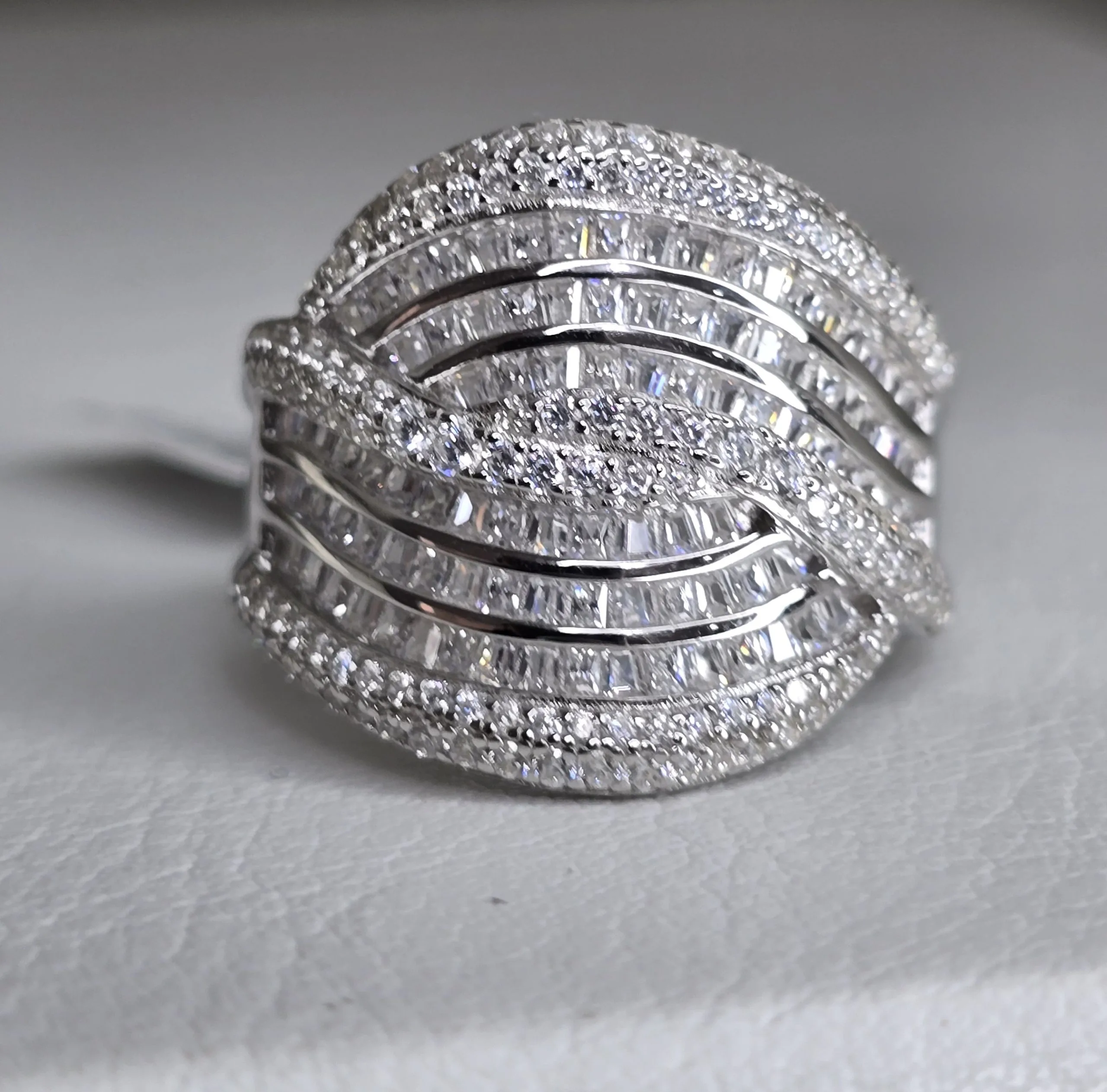 Importante anillo de plata rodinada cruzado, con cubics engarzados. Importado