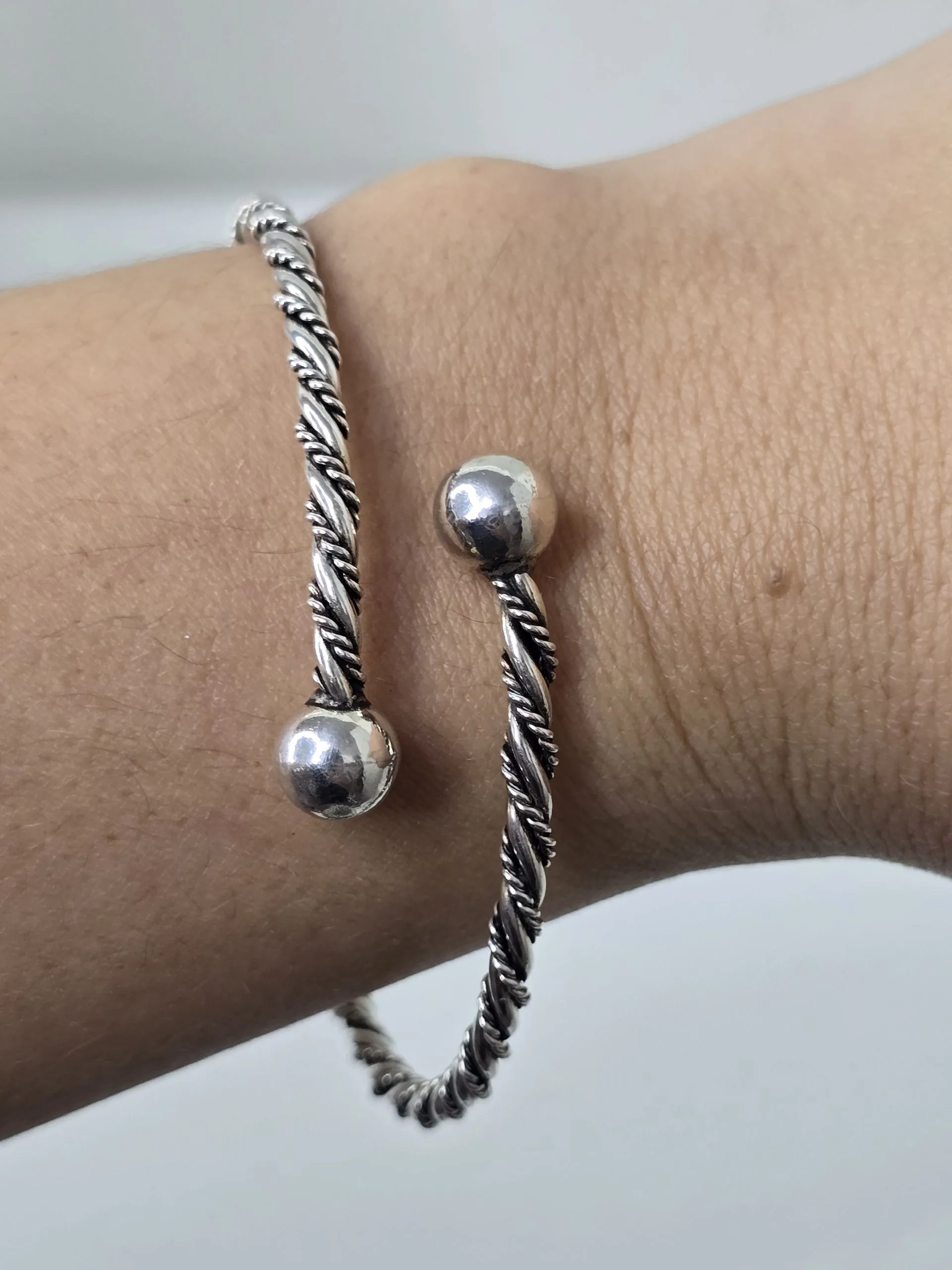 Esclava de plata abierta con bolas, labrada.