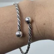 Esclava de plata abierta con bolas, labrada.