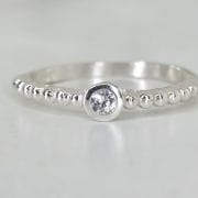 Anillo liso de plata con bolitas y punto luz