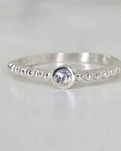 Anillo liso de plata con bolitas y punto luz