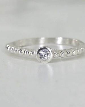 Anillo liso de plata con bolitas y punto luz